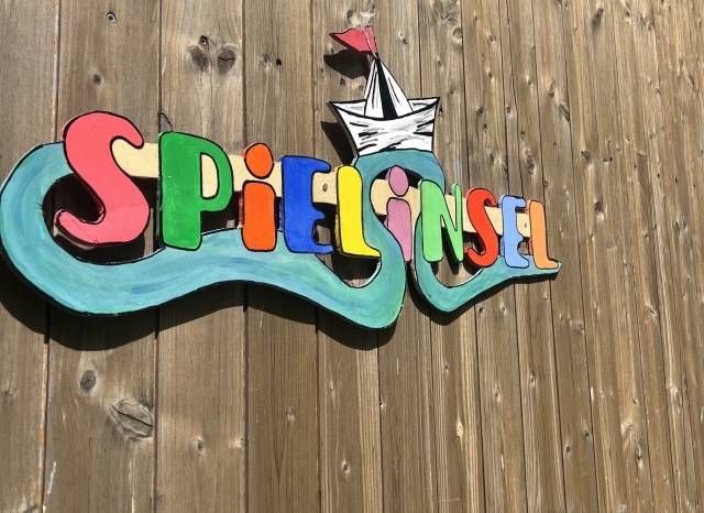 Symbolbild Spielinsel, Logo auf Holz